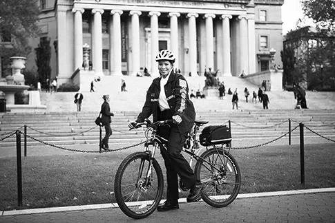 public safety staff on bicycle on college walk in front of low library