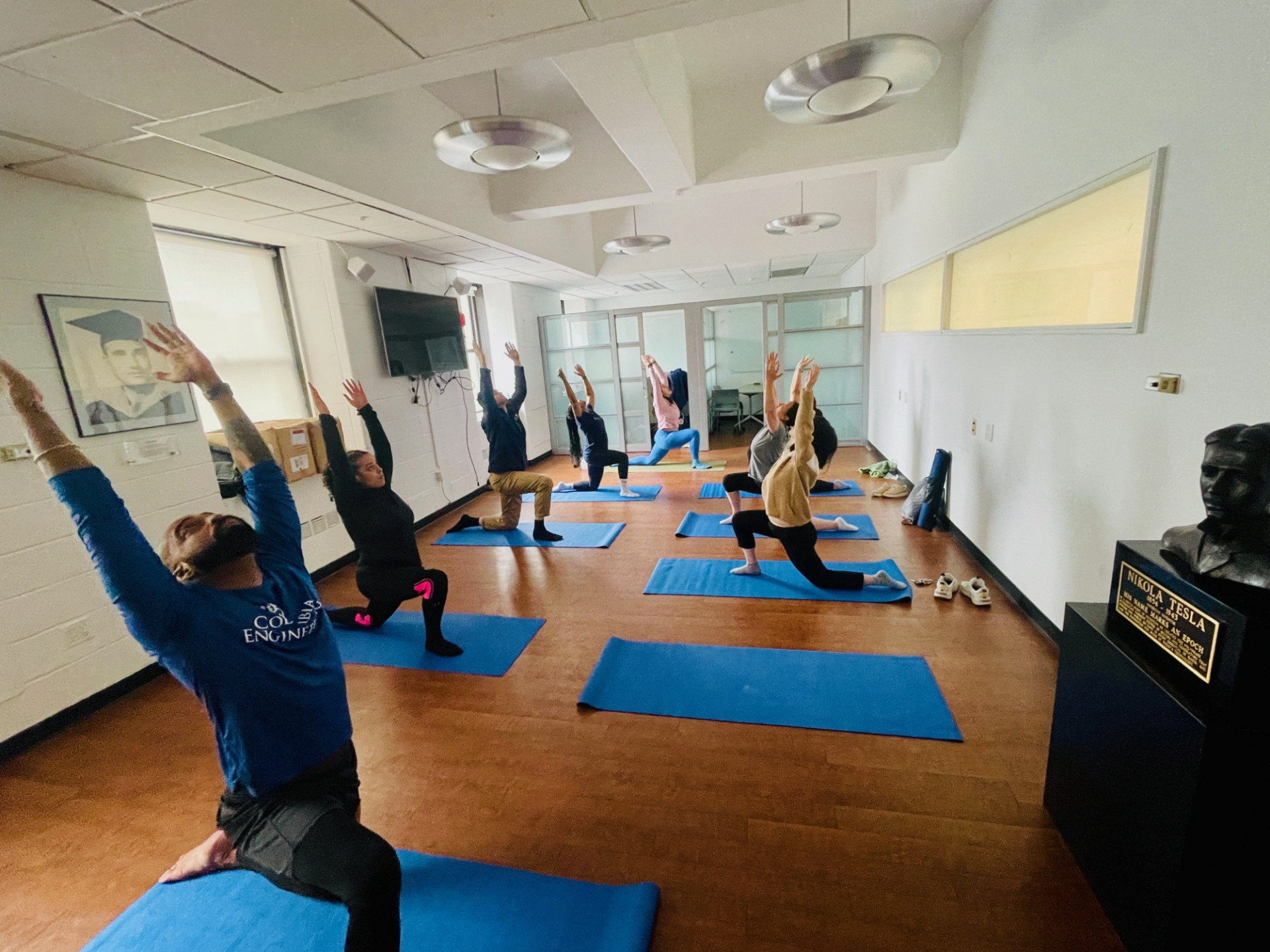 Columbia Engineering staff  stretching on floor reaching for ceiling 