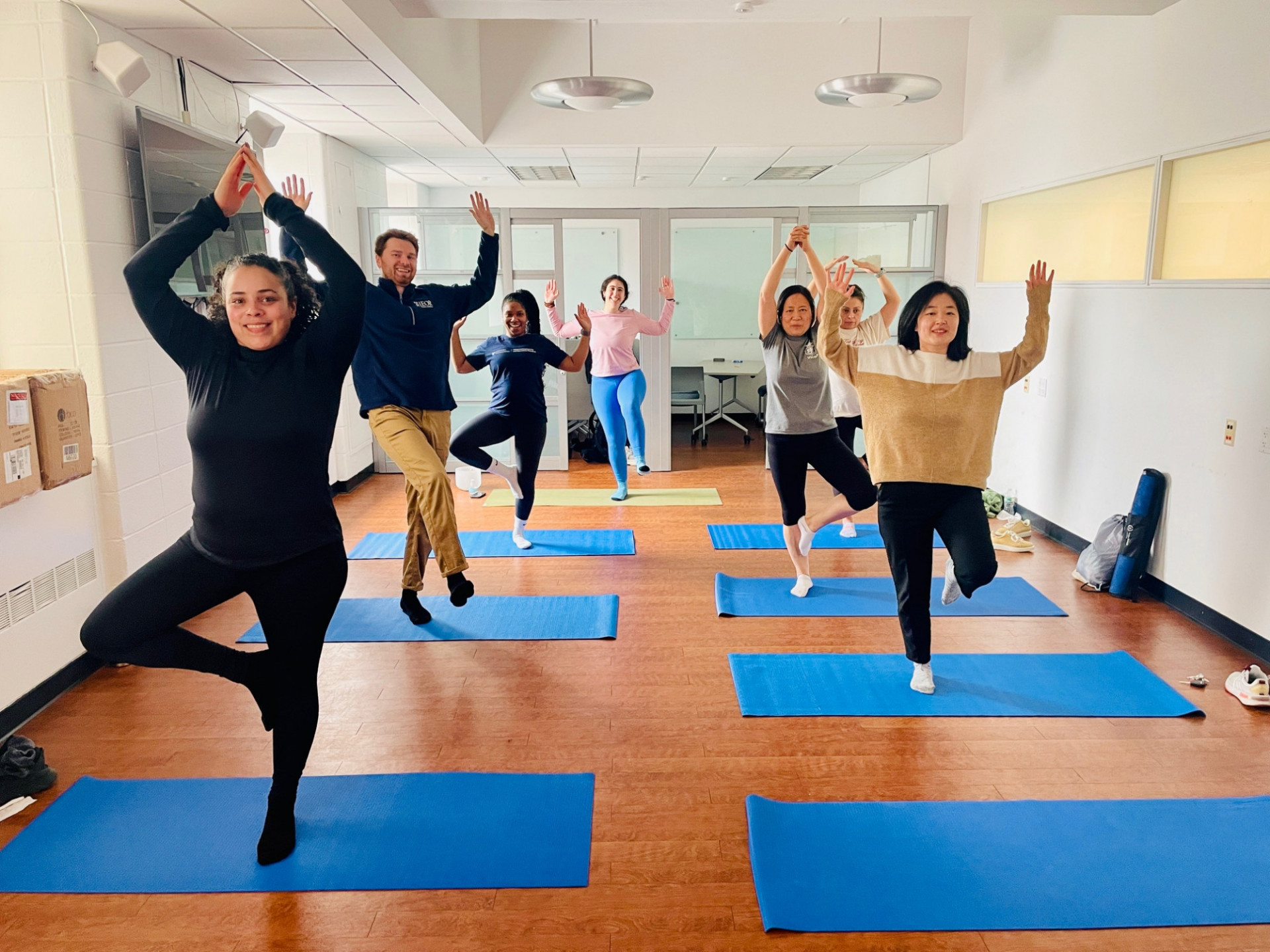 Columbia engineering staff performing a yoga crane pose