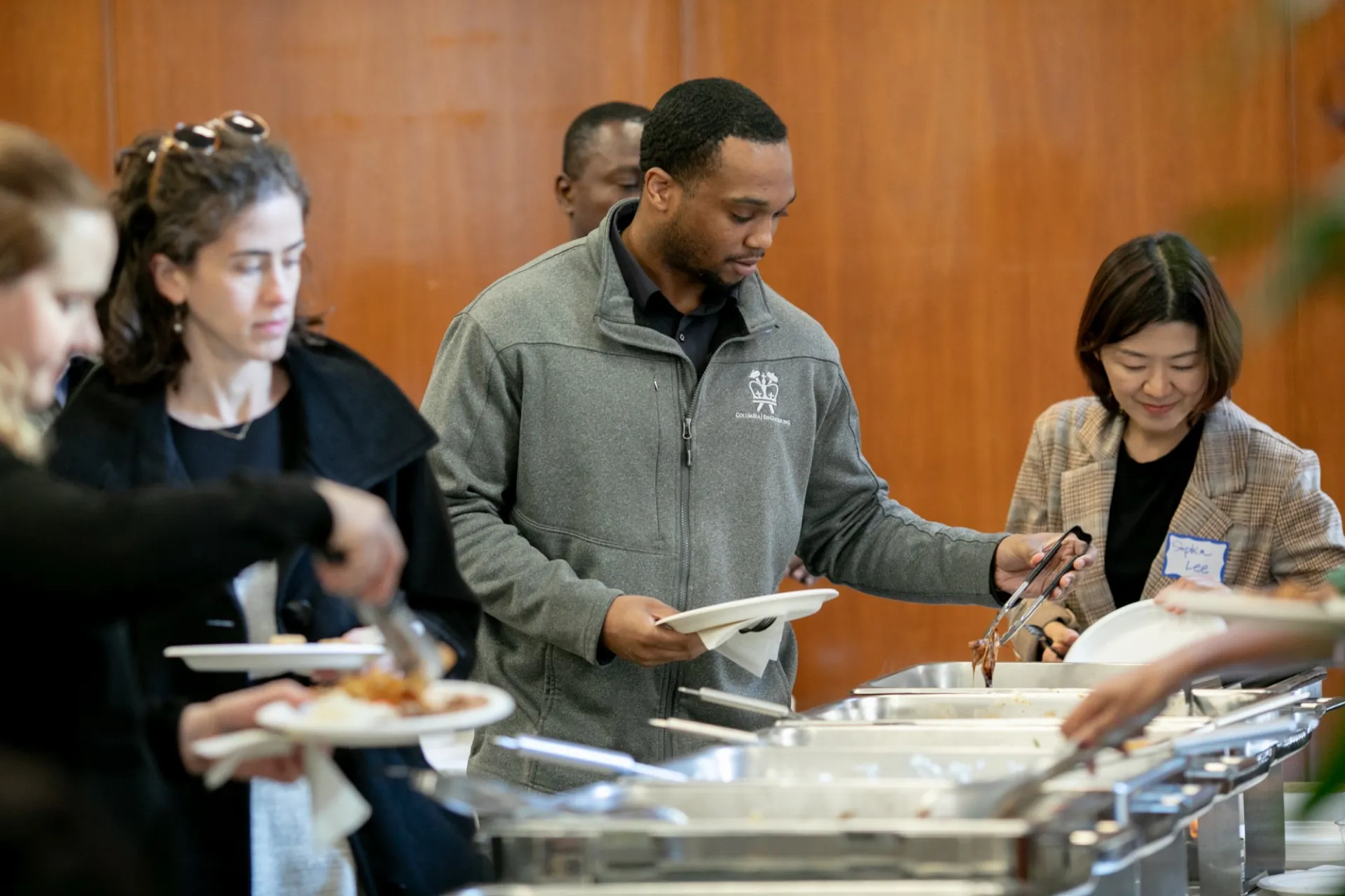 Columbia Engineering staff filling plates with food.