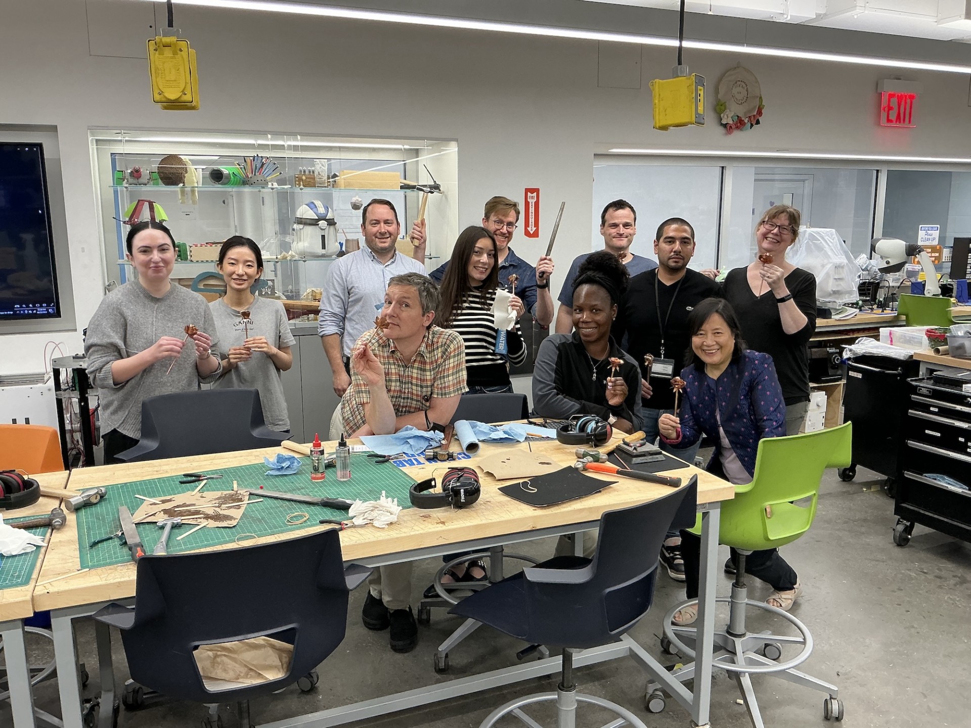 11 Columbia Engineering Staff posing for a photo with their copper roses in the Columbia Makerspace