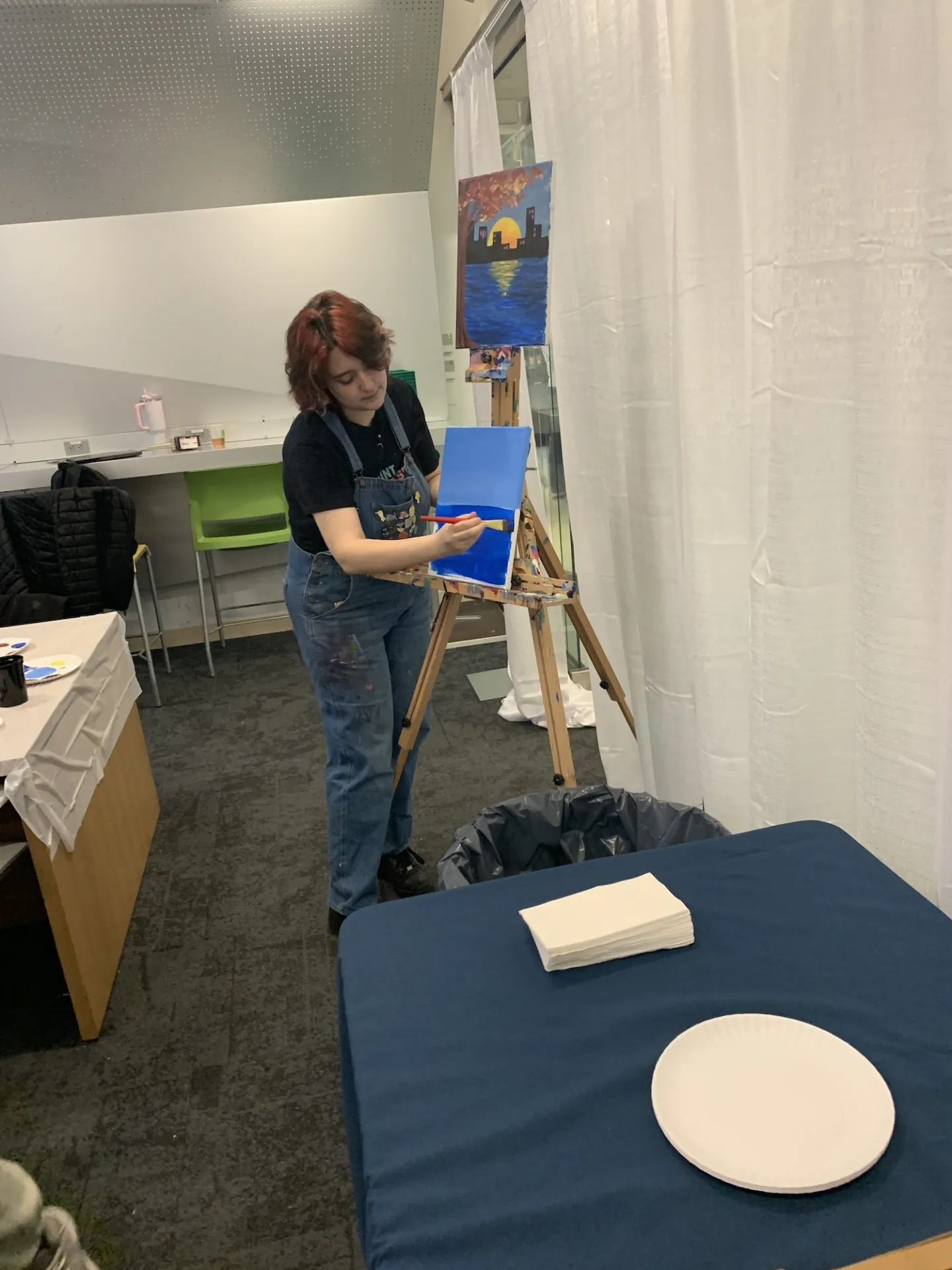 A painting instructor standing at the front of the room demonstrating techniques