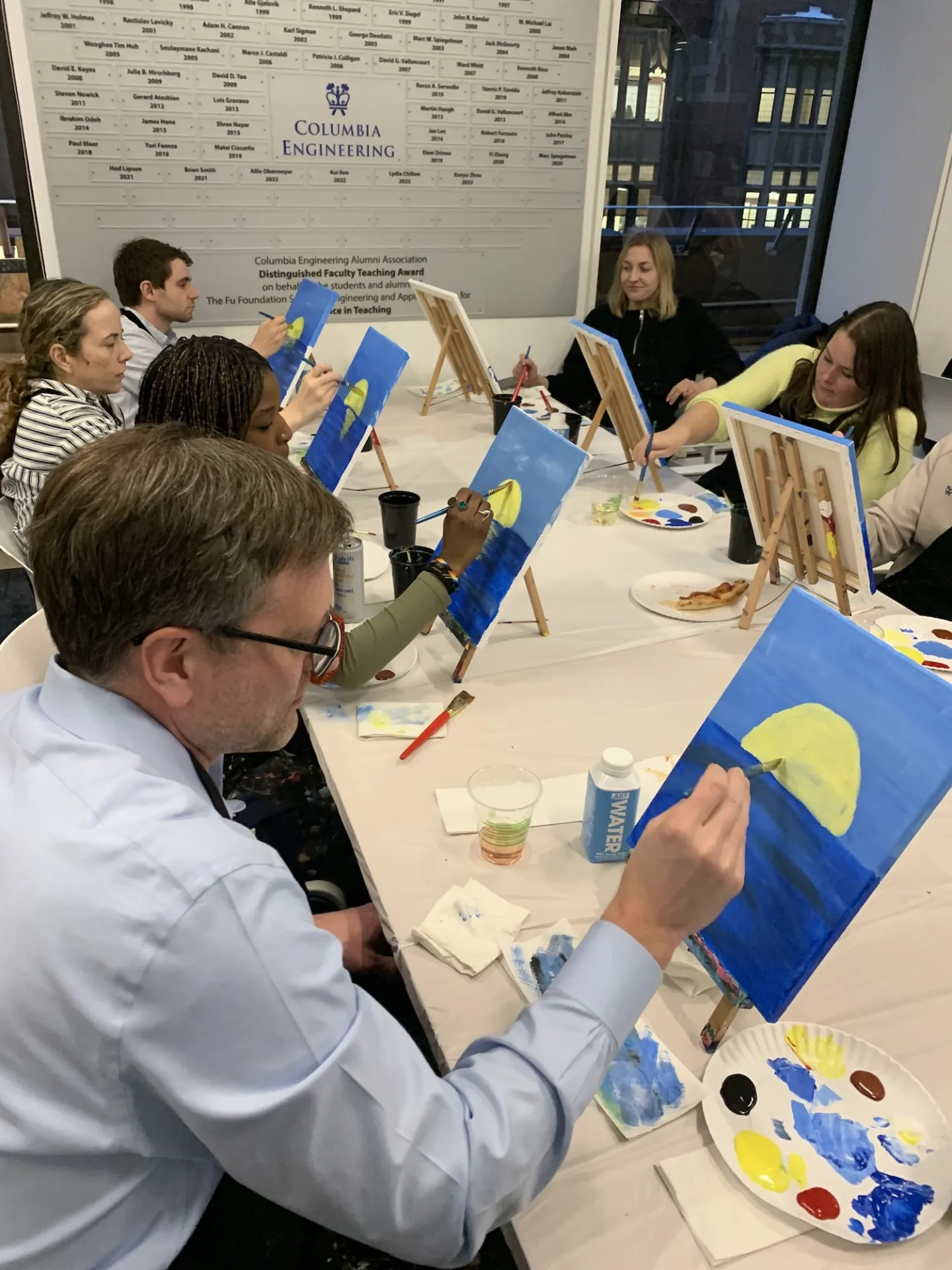 Columbia Engineering staff painting moons on their canvases