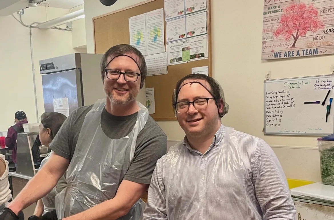 Two Columbia engineering staff smiling while preparing meals