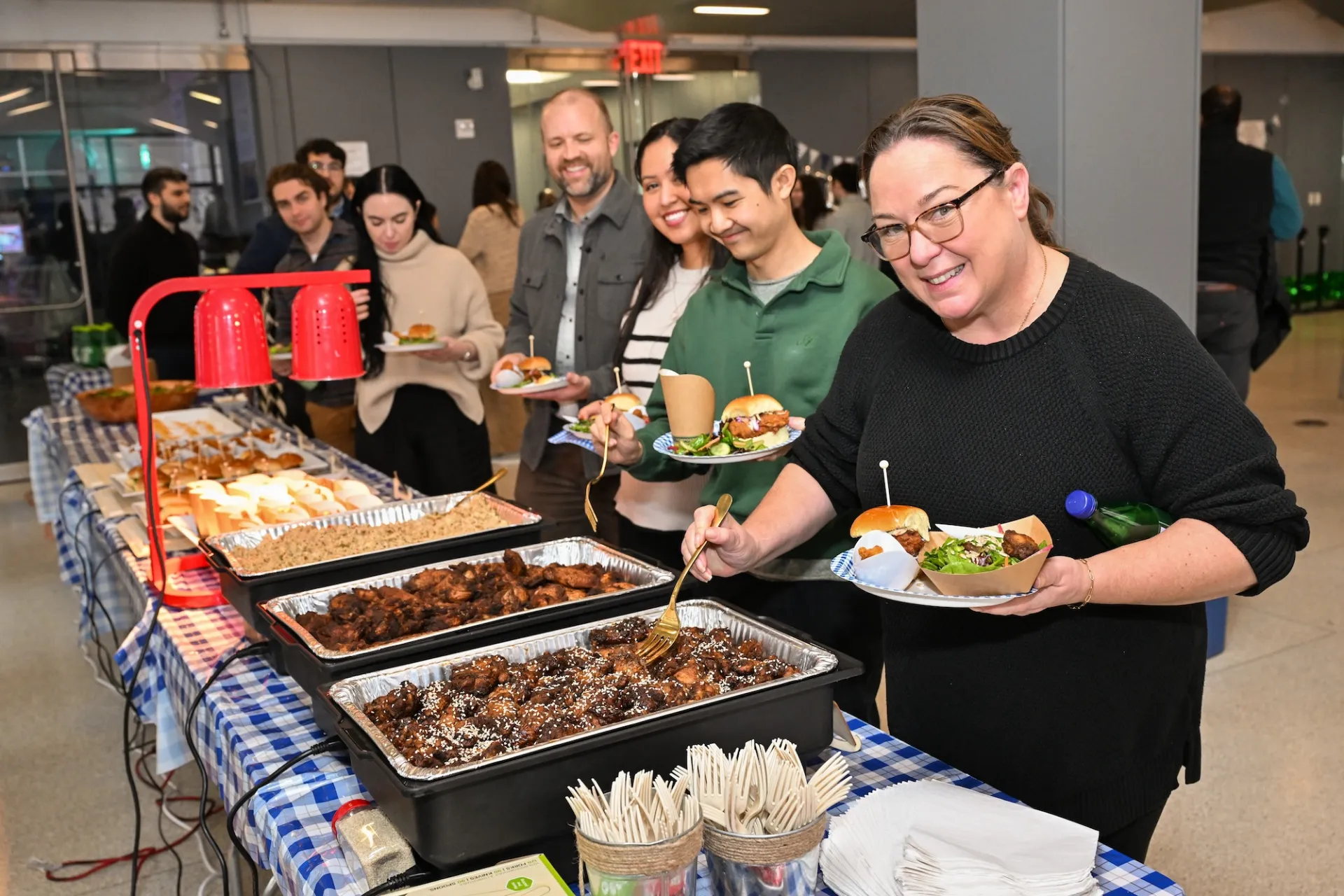 People in-line at a buffet filling their plates