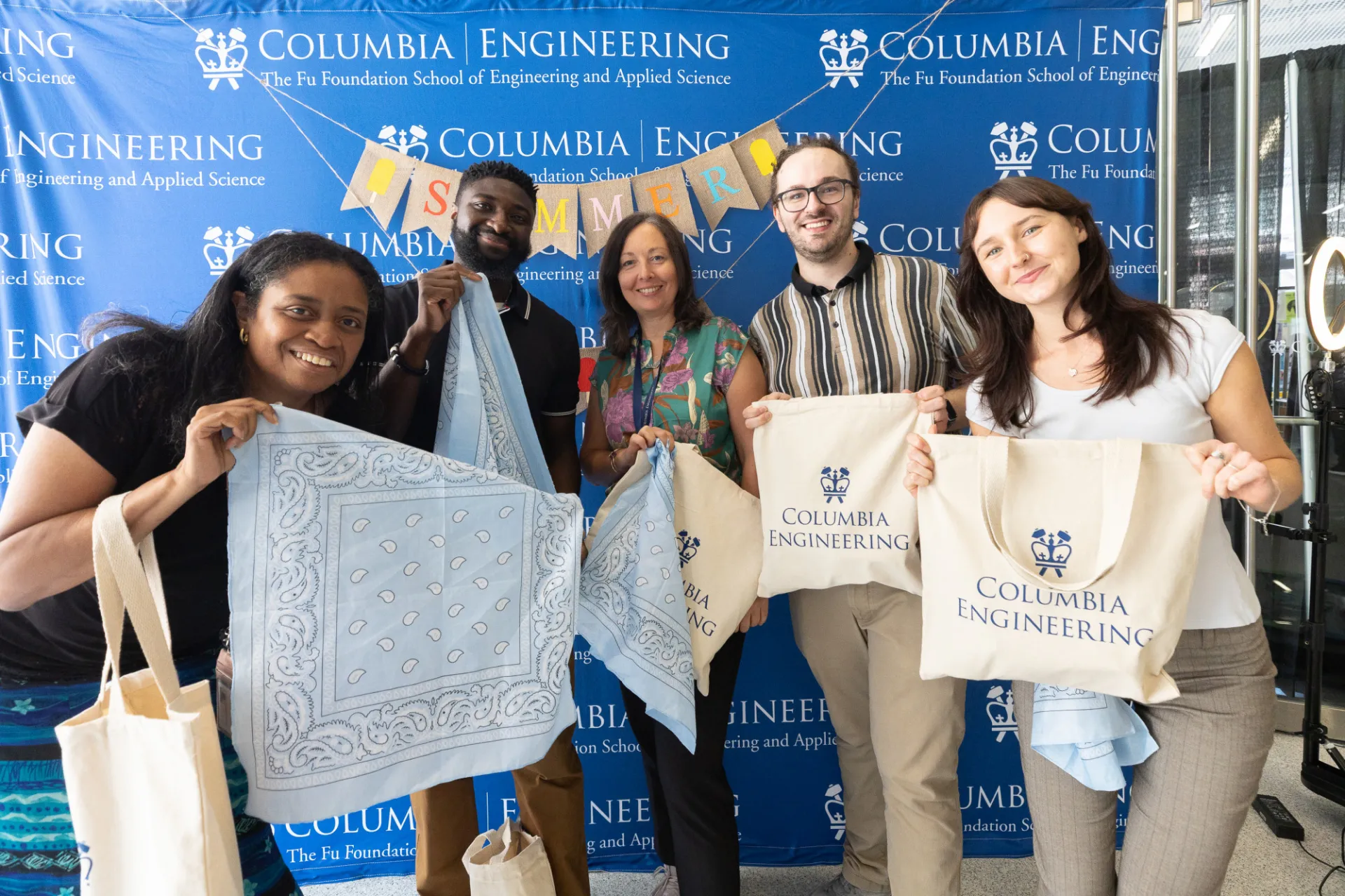 Staff members with blue bandanas presenting their prizes 