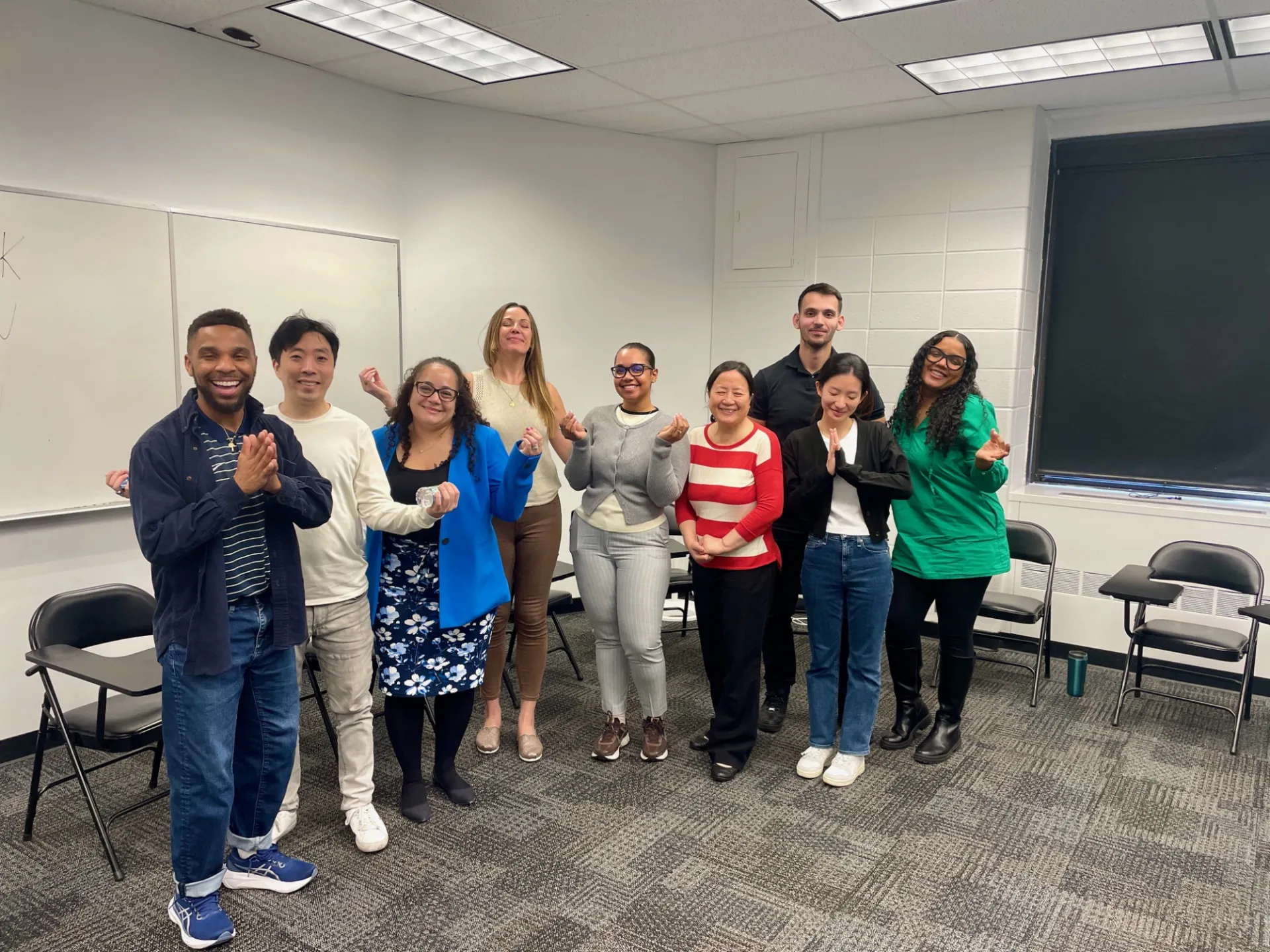 Staff grouped in a meditation pose smiling