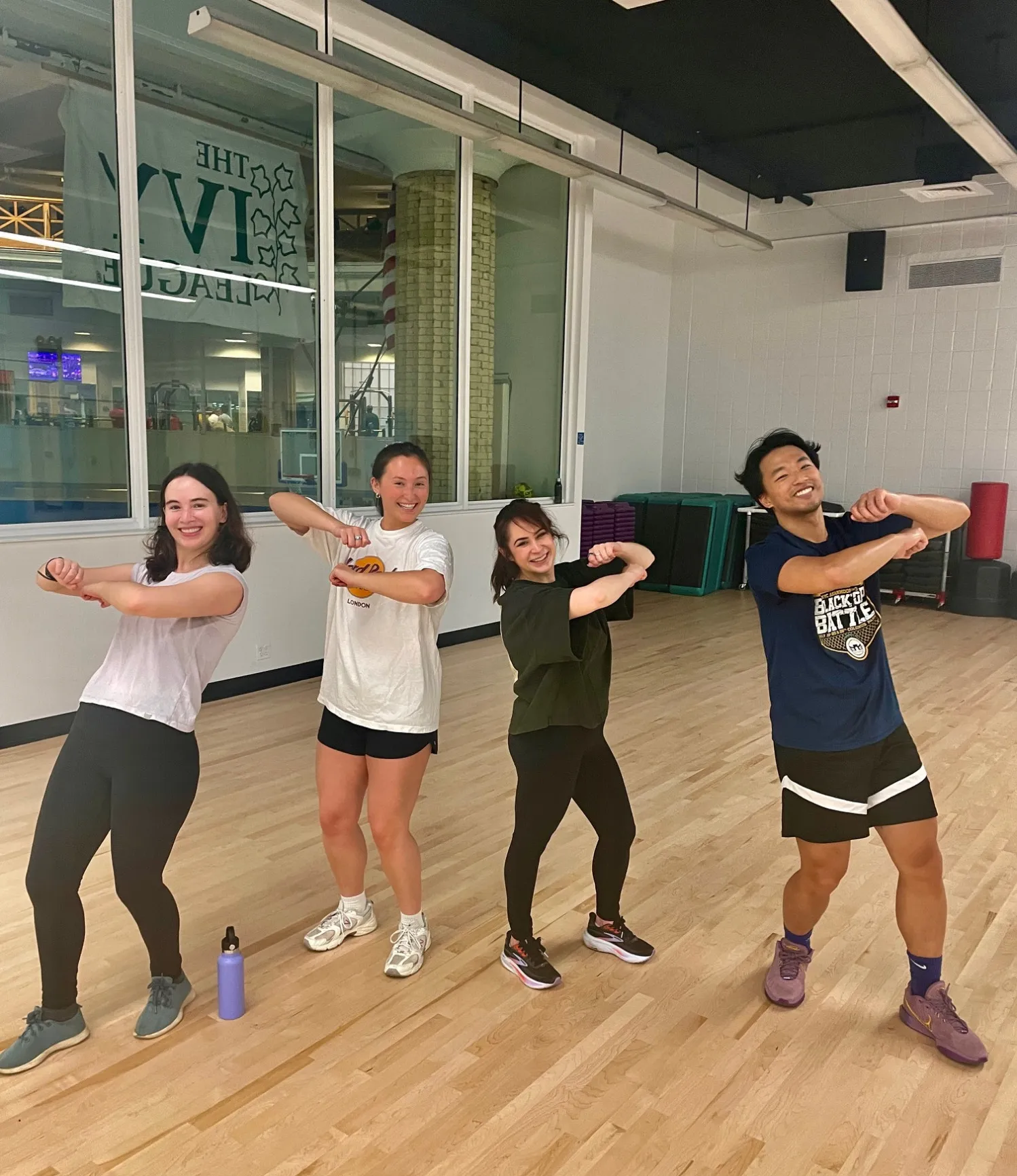 Four staff members posing in a dancing motion while smiling 