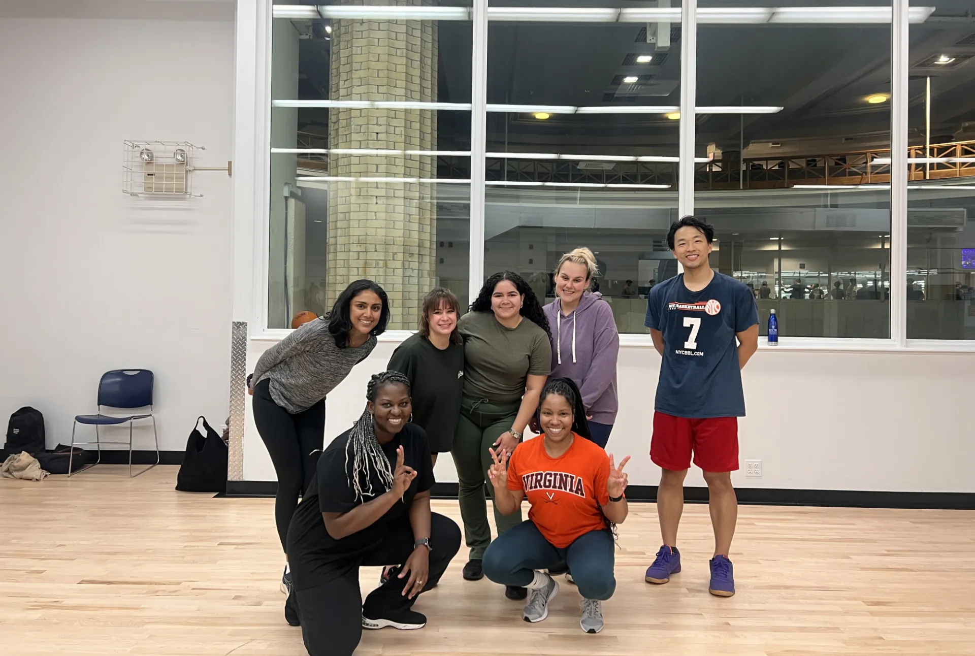Seven staff members in a gym smiling in workout clothes