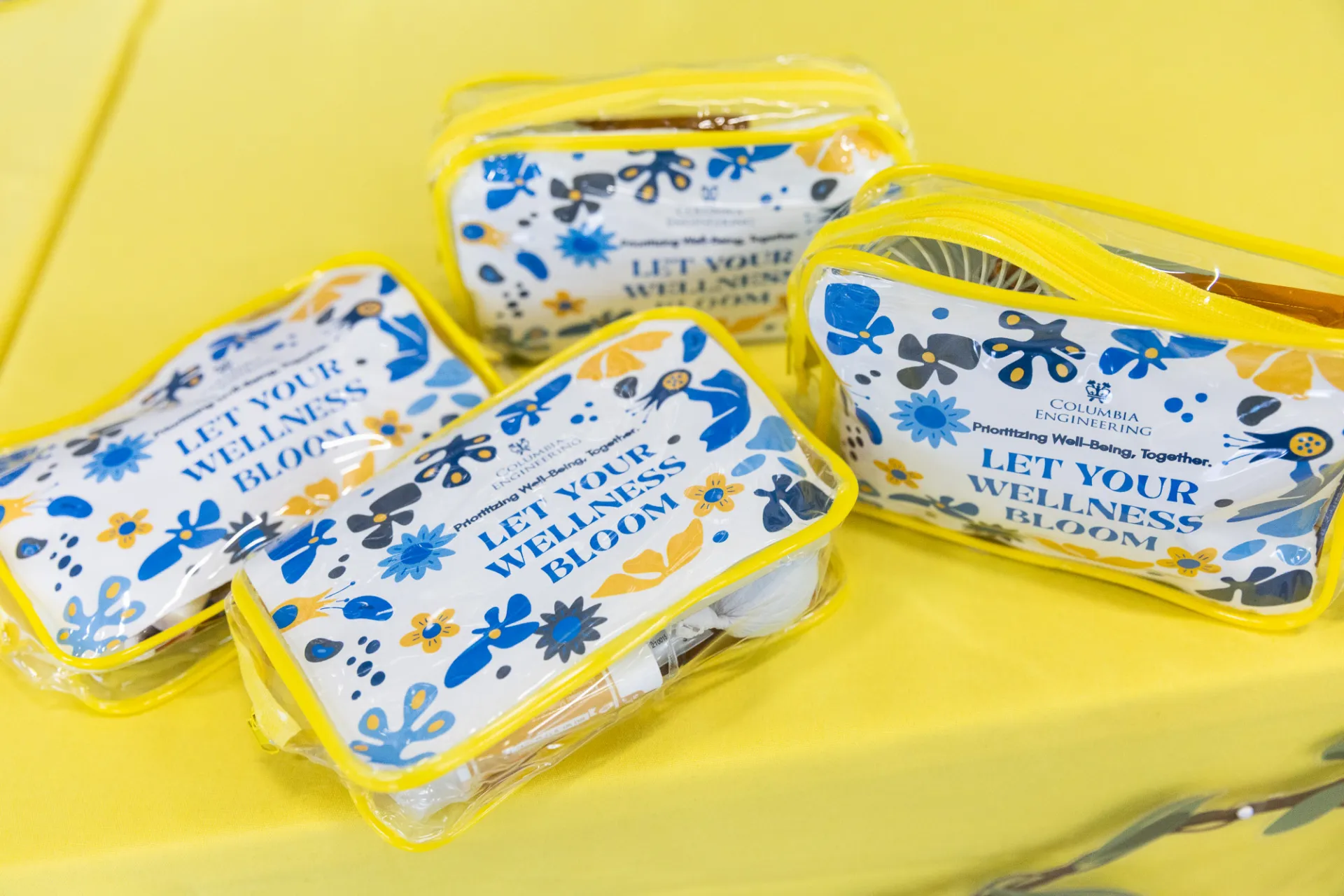 Four wellness essentials kits in yellow bags
