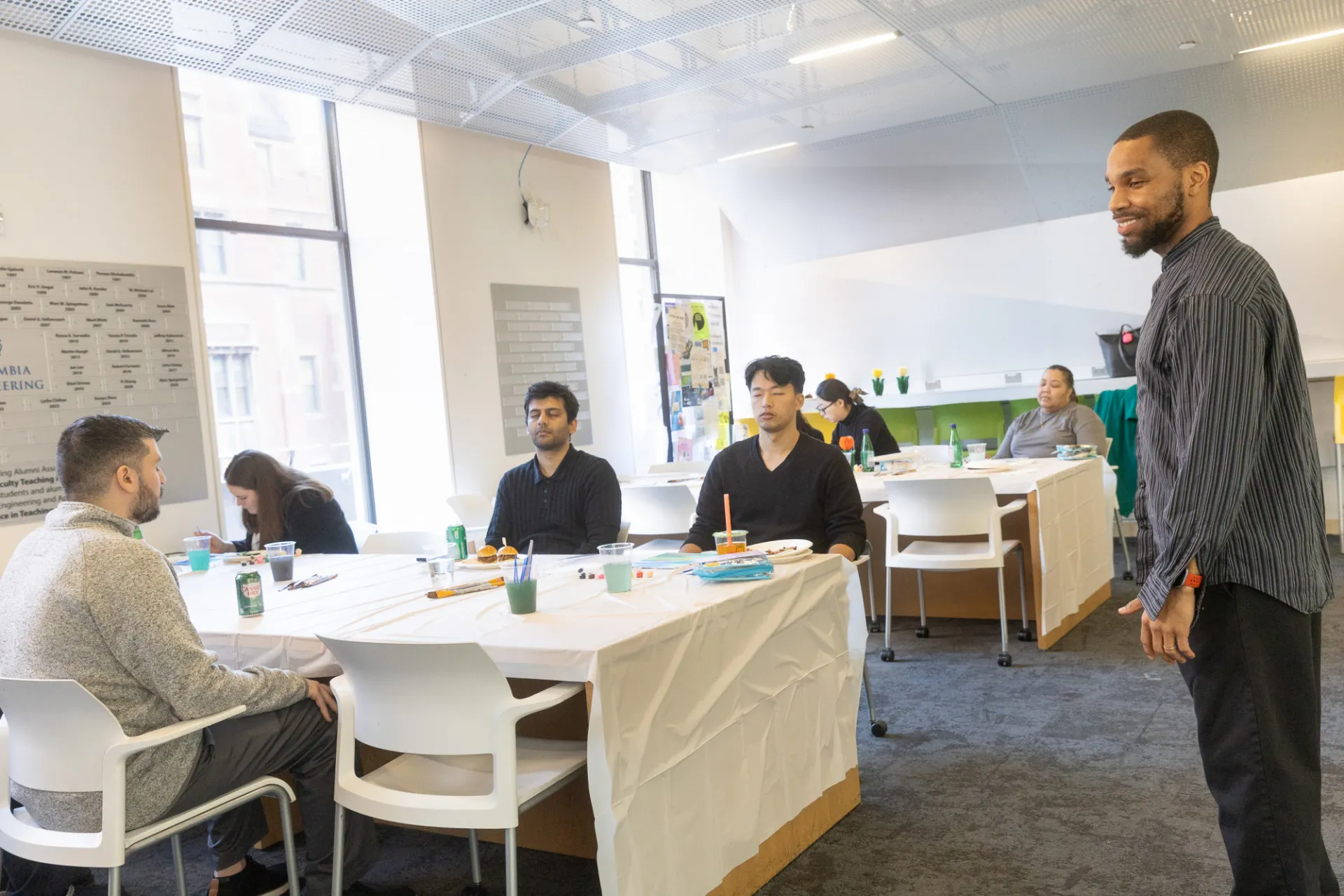 Staff members meditating while a gentleman in a gray shirt leads them