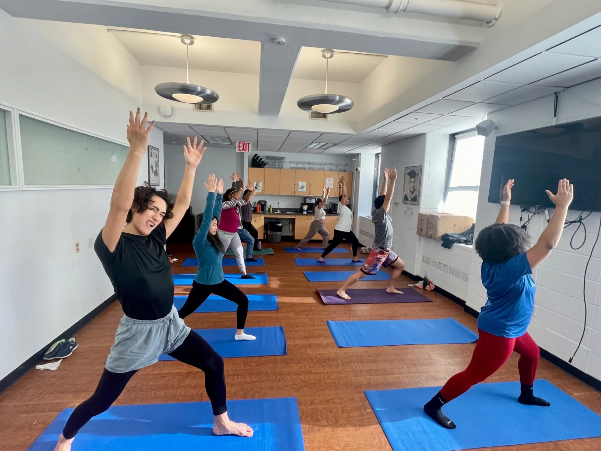 Several staff doing yoga with their hands in the air