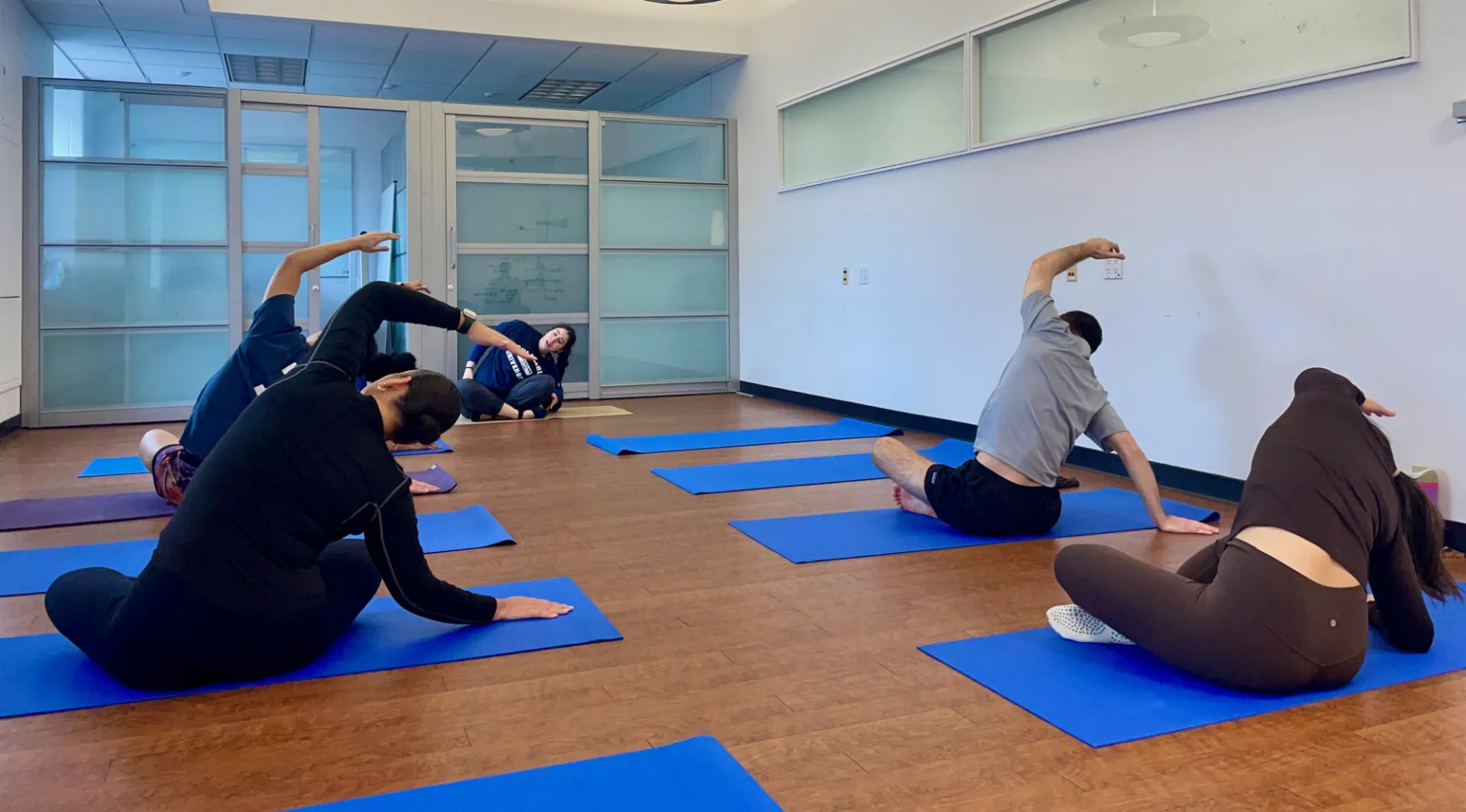 Several staff sitting and reaching sideways 