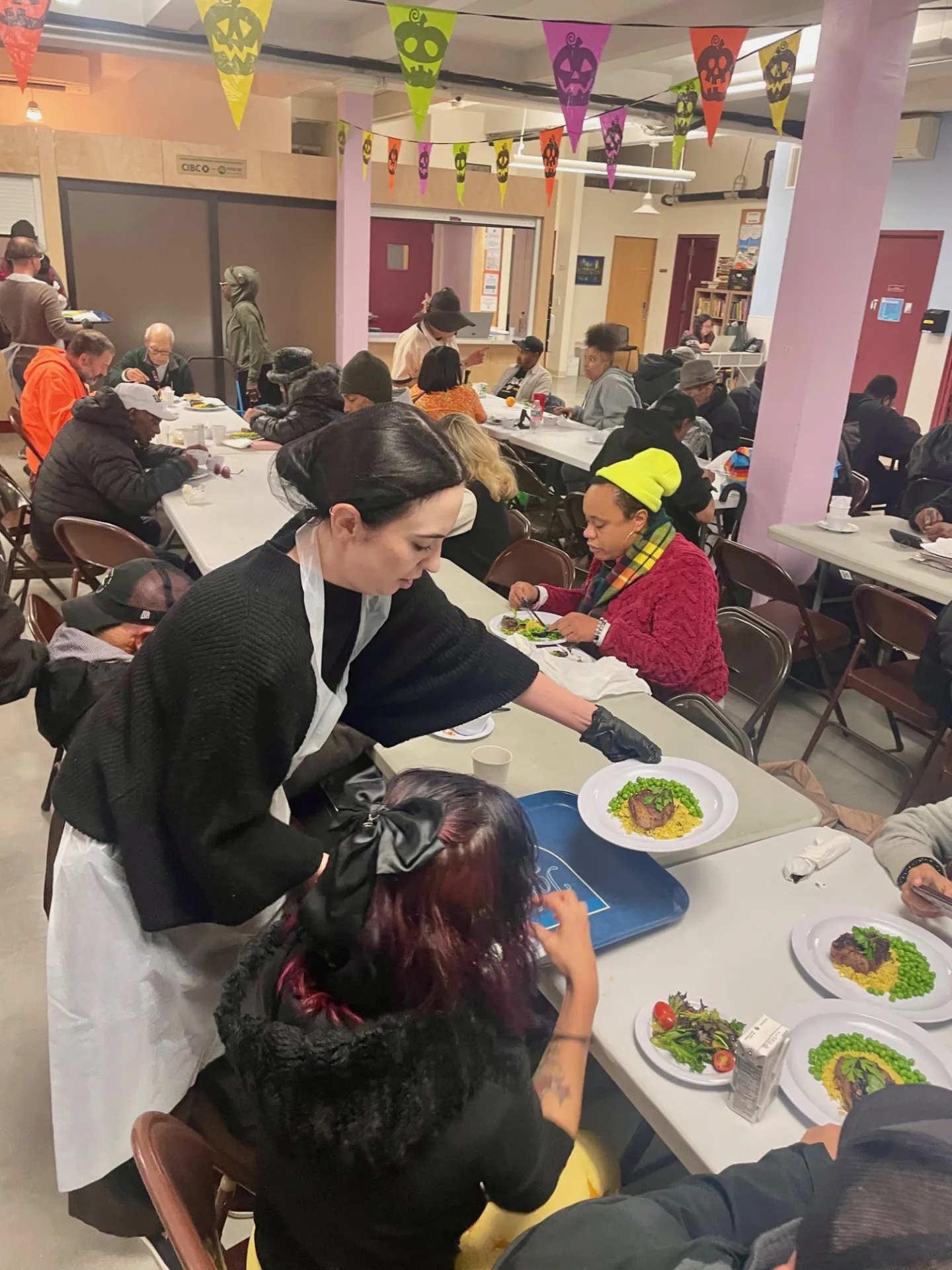A staff member serving a meal to another member of the community 