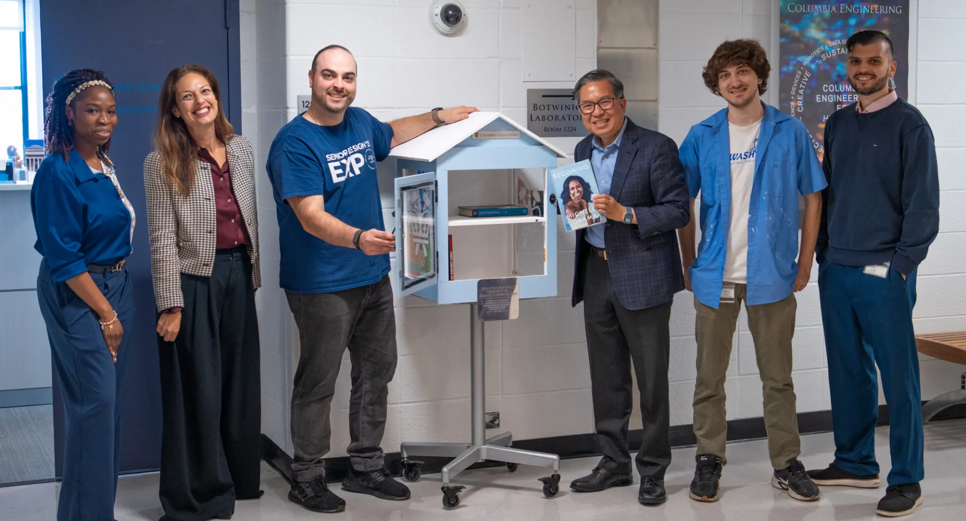 Group photo of 6 staff members and a little library