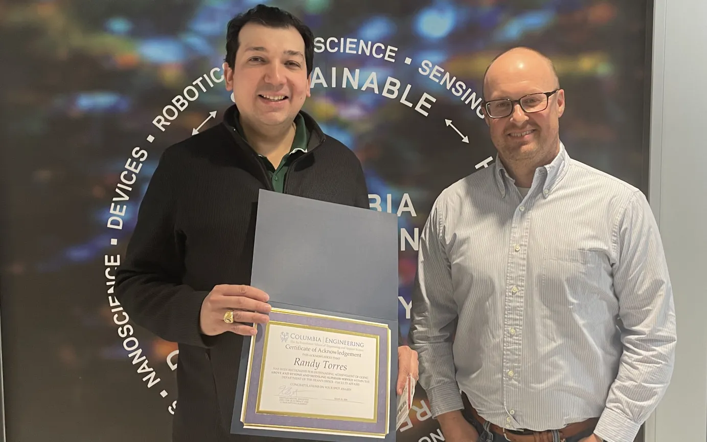 Randy and Kristian posing for photo holding a certificate