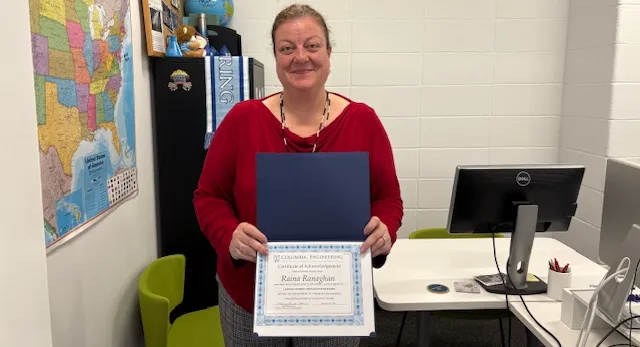 Raina Ranaghan holding her certificate for her Spot Award